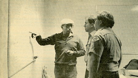 Paramedic Rick Terrell, center, receives a quick briefing from Doug Magee, left, of the June Lake Mountain Rescue Team