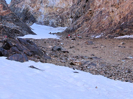 The route down over loose bolders to the snow slope