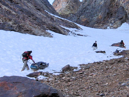 Belaying the victim in litter down the snow slope