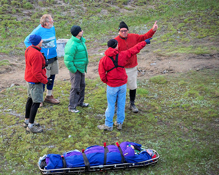 SAR members discuss the situation while the pilots prepare the helicopter